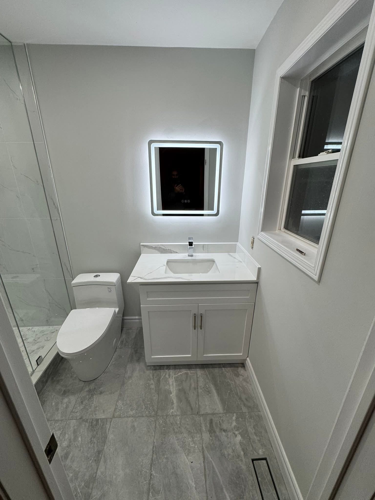 Luxury bathroom renovation Oakville — LED backlit mirror, custom white cabinetry, quartz countertop by Cruzz Construction