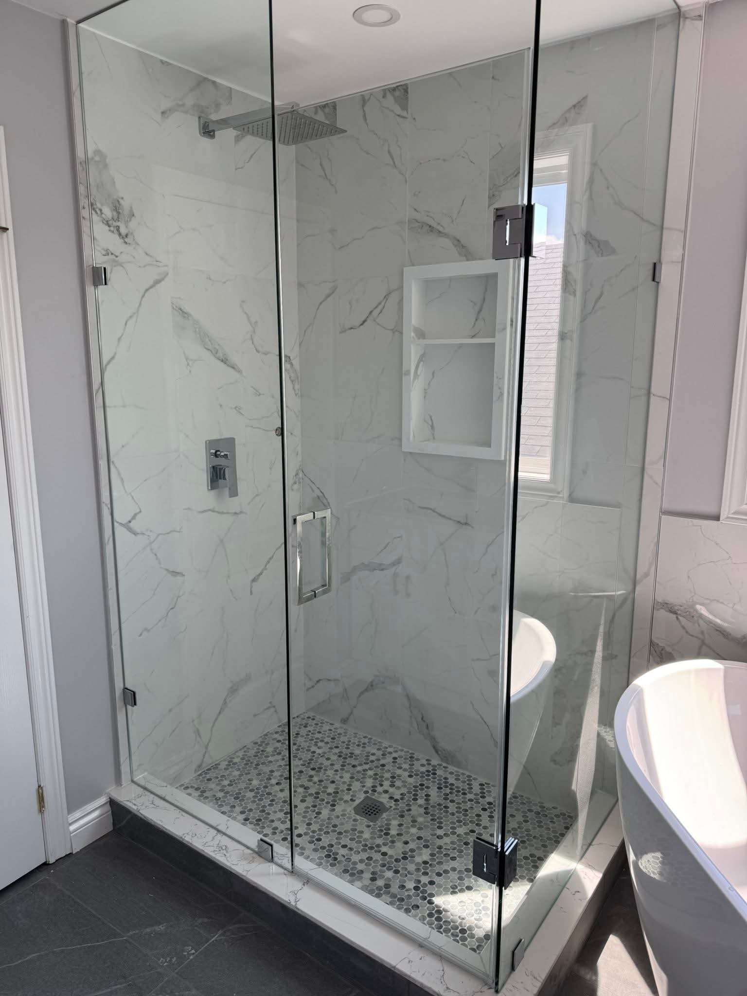 Luxury bathroom renovation Oakville — walk-in shower with frameless glass and marble penny tile floor by Cruzz Construction