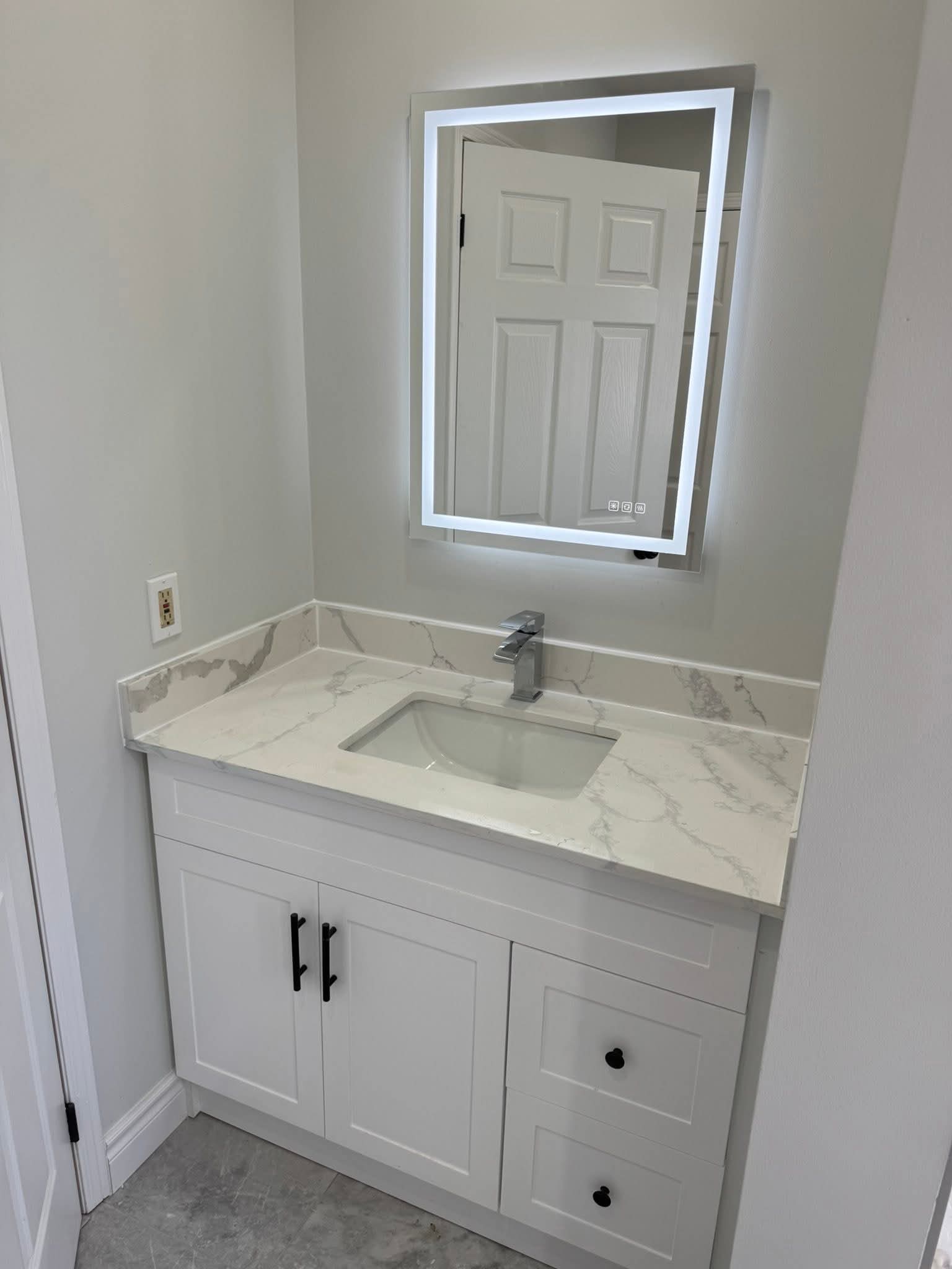 Oakville bathroom renovation — white shaker vanity with quartz countertop and LED mirror by Cruzz Construction